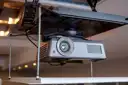 Thumbnail of A projector mounted to a motorised mechanism lowered from the ceiling