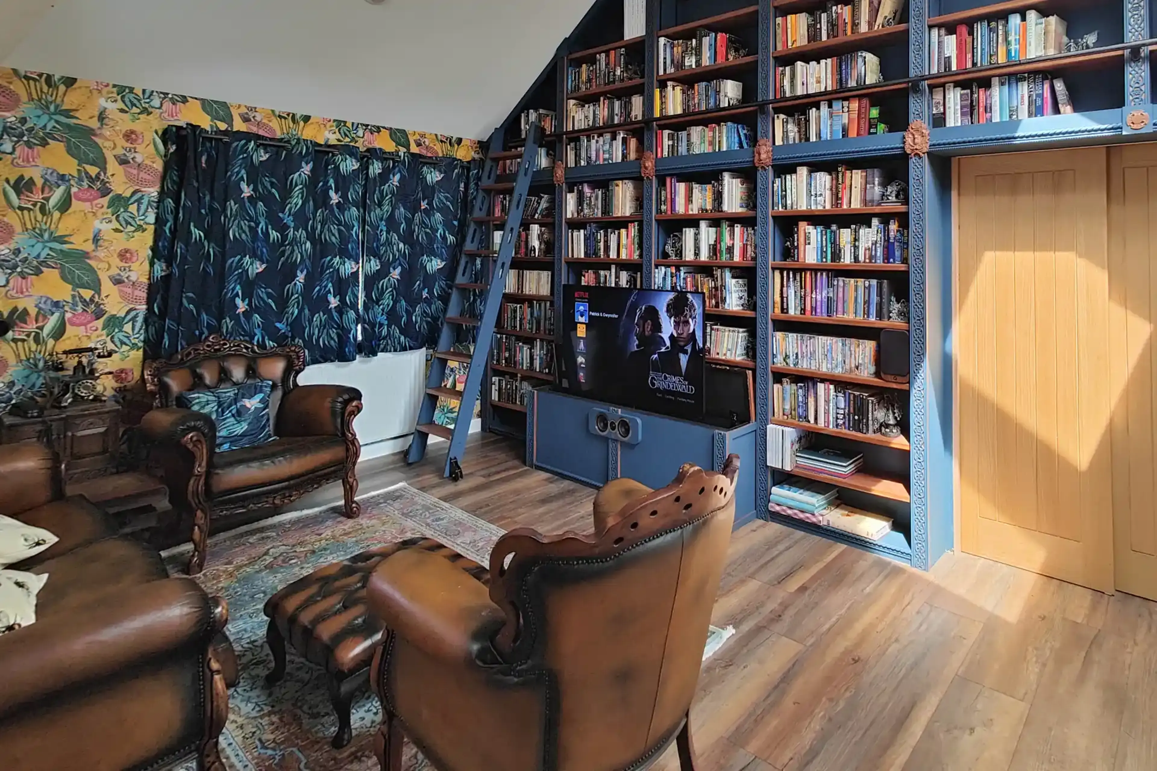 A custom-built library with a TV raised inside a seating unit by a Venset TS1000A TV Lift