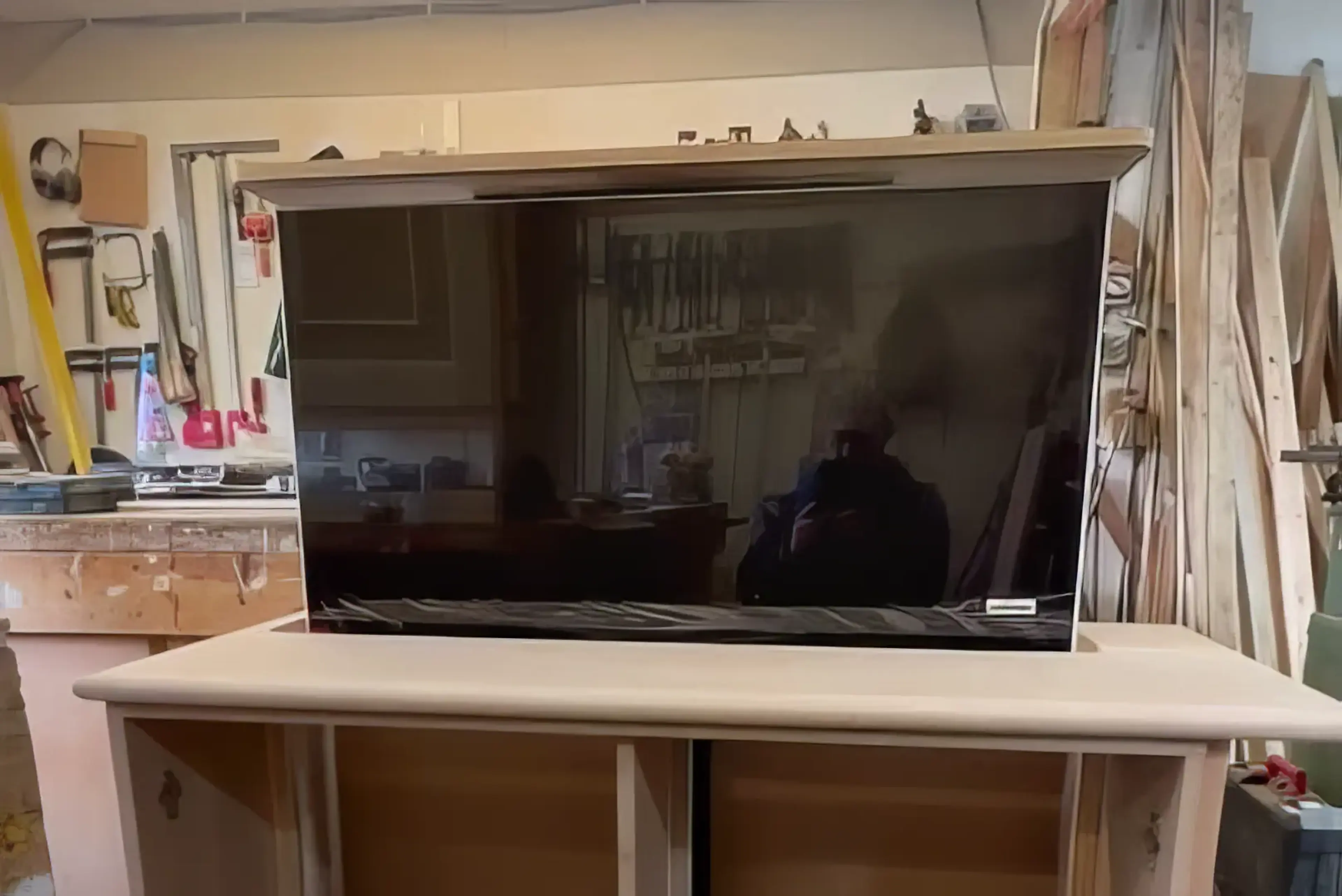 A TV raised from a cabinet that's half constructed