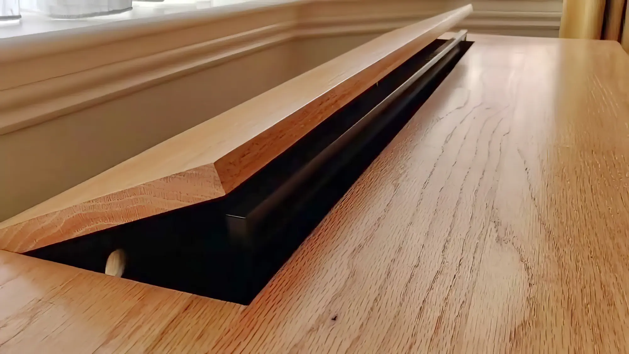 A TV emerging from within a cabinet with a hinged lid