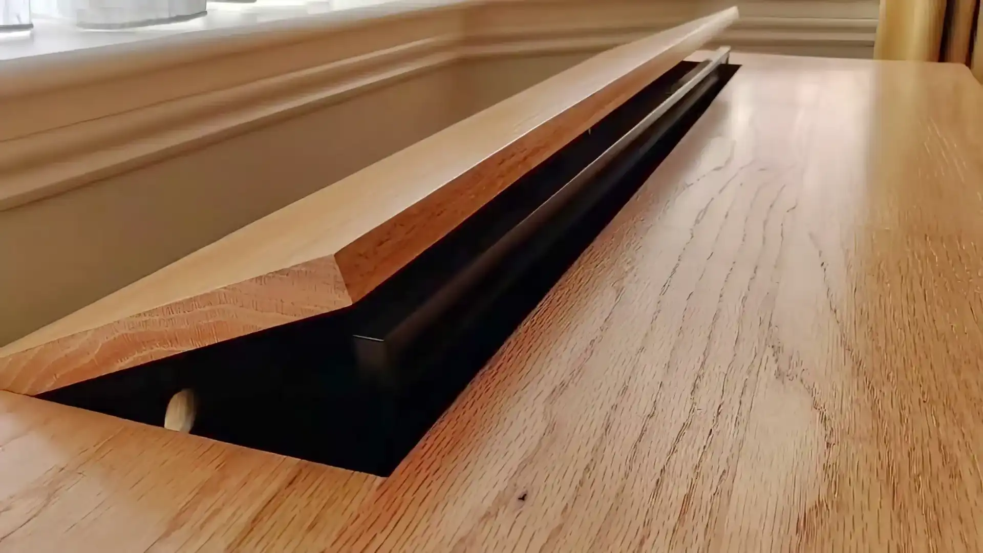 A TV emerging from within a cabinet with a hinged lid