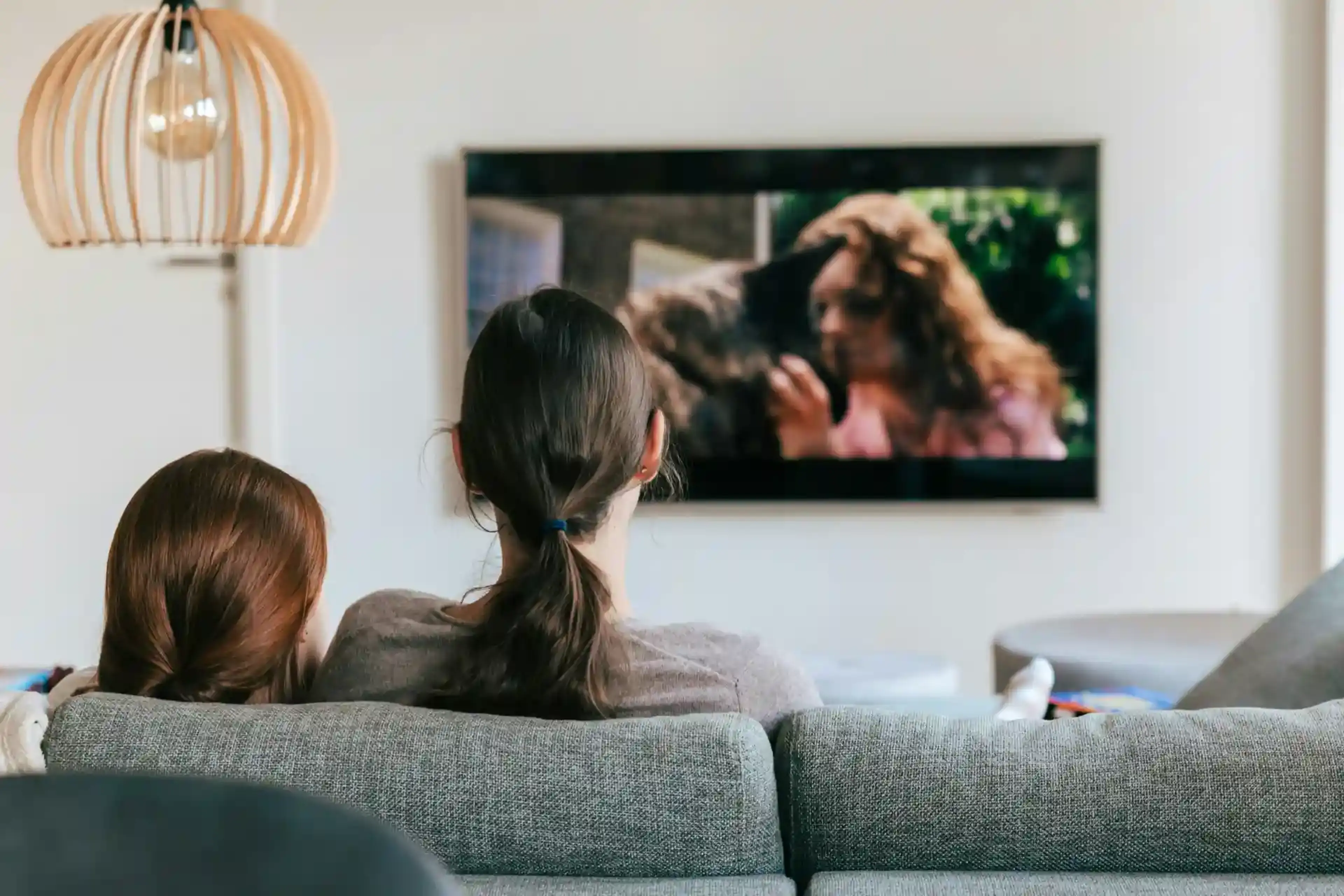 Rear view of a family watching TV in a living room