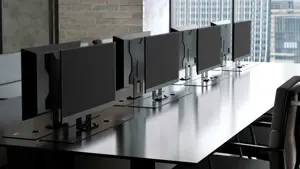 A collection of monitor lifts built into a conference desk with monitors mounted on them
